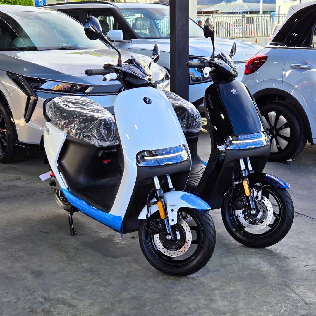 Ninebot E125 MK2 - Gris y Negro (dos unidades) - Dos unidades, vista de tres cuartos. Hay dos motocicletas: una gris claro y otra negra, ambas con detalles azules.
