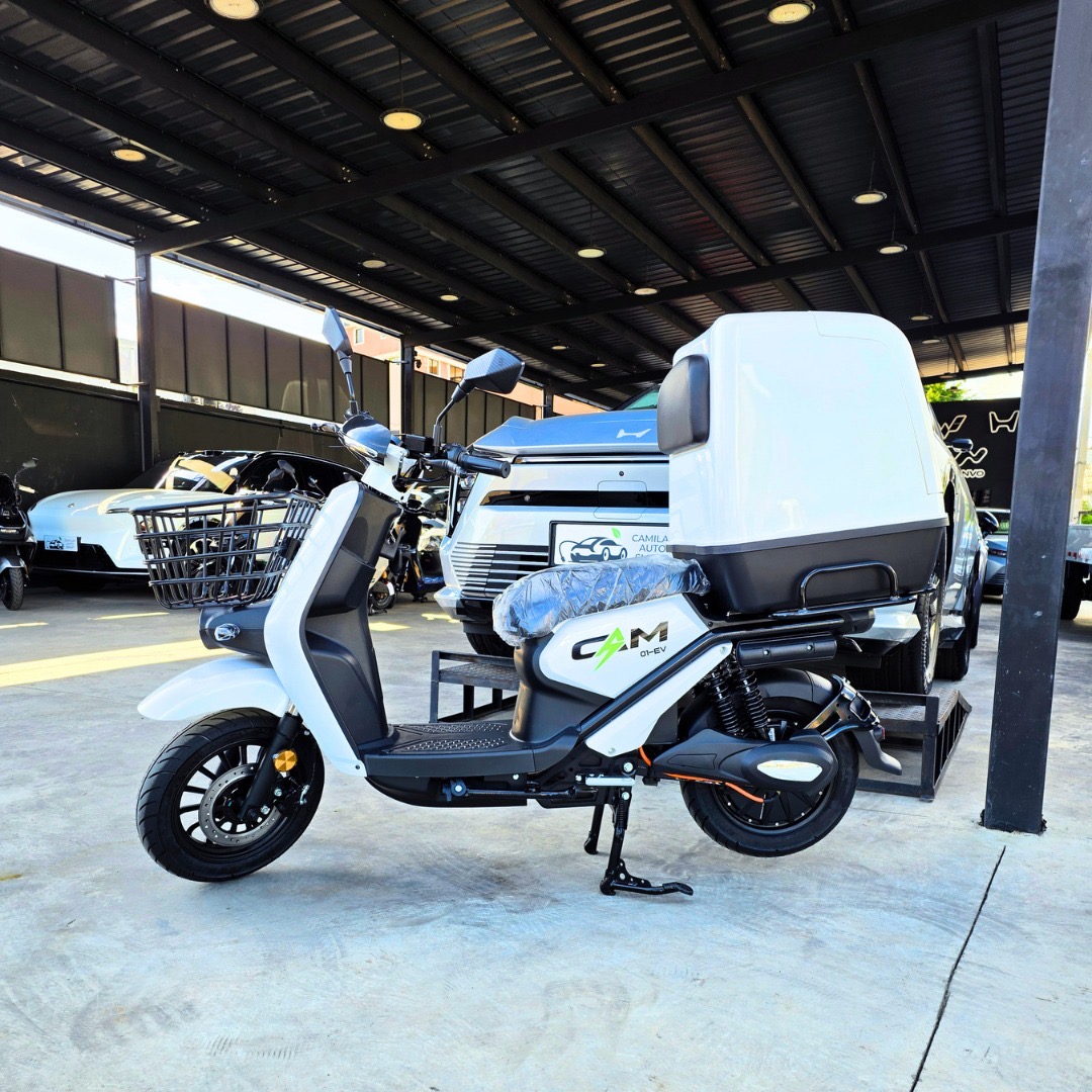 CAM 01-EV 2026 - Blanco - Vista lateral con box trasero. Caja plástica blanca cerrada opcional: US$200 adicionales. Compatible con CAM 01 EV y CAM 02 EV; no incluida en el precio base de la moto.